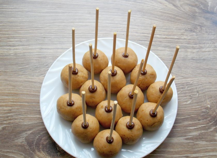 1. Этап. Кейк попсы из печенья: Сразу воткните палочки шоколадным концом в подготовленные шарики. Поставьте снова на 30 минут, чтобы шоколад застыл.