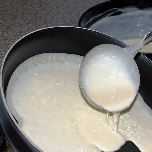 1. Этап. Блинчики на кислом молоке: Разогреваем сковороду с небольшим количеством масла. На раскаленную сковороду выливаем немного теста, равномерно распределяем по всей сковороде.