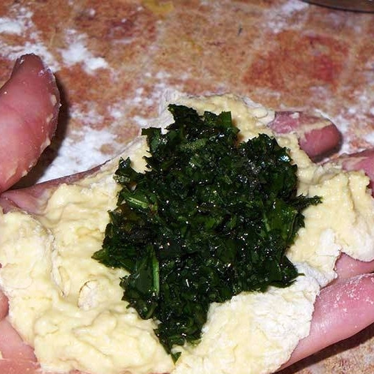 1. Этап. Пирожки со щавелем: Кладем на лепешку немного начинки.