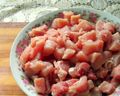 1. Этап. Вкусные горшочки со свининой: Мясо зачистите от пленок и жилок. Промойте под проточной водой и обсушите. Нарежьте кубиками. Лучше всего для этого блюда подойдет задняя часть или лопатка.