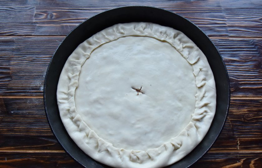 1. Этап. Табасаранское чуду: Оставшуюся часть теста раскатайте в круг меньшего диаметра и выложите поверх начинки. Закрепите нижний и верхний слои теста между собой. В центре чуду сделайте отверстие для выхода пара. Сбрызните чуду водой.