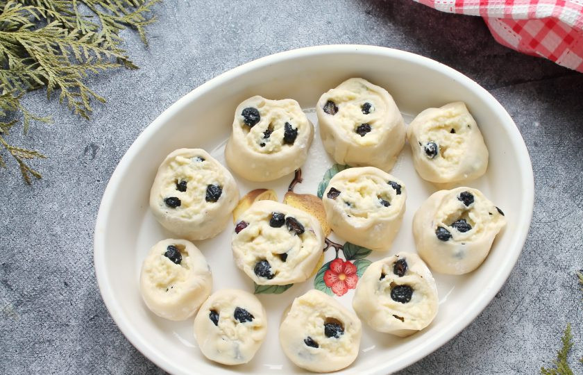 1. Этап. Булочки с голубикой: Сверните прямоугольник в рулет в сторону пустого края и защипните шов. Разрежьте рулет на кусочки 3-4 сантиметра и выложите в смазанную маслом форму разрезом вверх. Накройте форму и уберите в теплое место на 25-30 минут для расстойки.