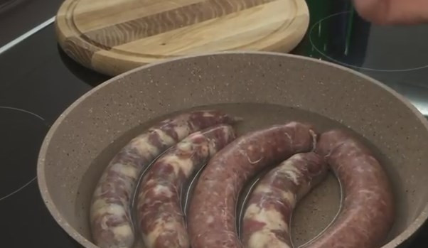 1. Этап. Вкусные и сочные домашние колбаски: 7. Для приготовления колбасы выложите ее в сковороду и до половины высоты залейте водой, чтобы она сначала пропарилась, а не сразу жарилась. Через 10 минут переверните на вторую сторону.