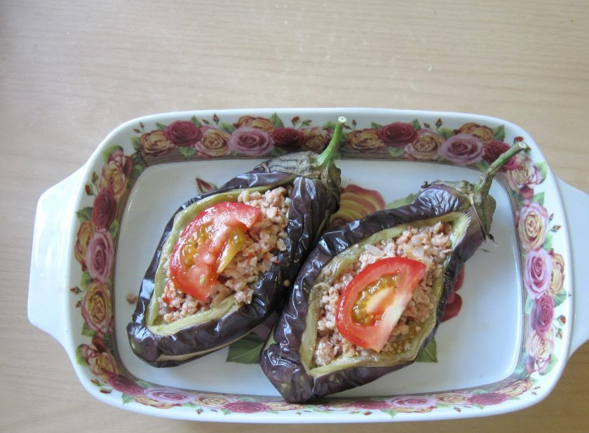 1. Этап. Баклажаны с фаршем в духовке: Выложите в каждый баклажан пластинку помидора.