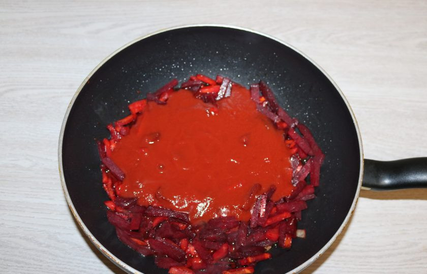 1. Этап. Борщ с карасями: Добавьте томатную пасту в обжаренную морковь и свеклу. Хорошо перемешайте, немного потушите.