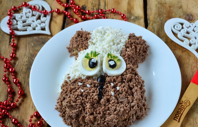 1. Этап. Новогодний салат в Год Собаки: С помощью яйца и маслин сделайте глаза, из белка сделайте усики, а из маслин или чернослива - носик. Украсьте салатик зеленью и подавайте!