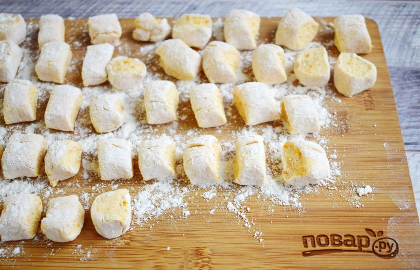 1. Этап. Тыквенные ленивые вареники: Рабочую поверхность присыпьте большим количеством муки. Окуните руки в муку. Каждую часть теста раскатайте в колбаску, нарежьте на кусочки по 2 см. При необходимости их можно заморозить и отварить в нужное время.