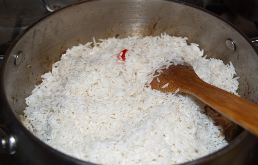 1. Этап. Мясо с рисом: Всыпьте промытый рис. Разровняйте его. Влейте 4 стакана кипятка. Добавьте соль и специи по вкусу. Закройте крышкой кастрюлю, уменьшите огонь. Варите без помешивания до готовности. Рис варится очень быстро.