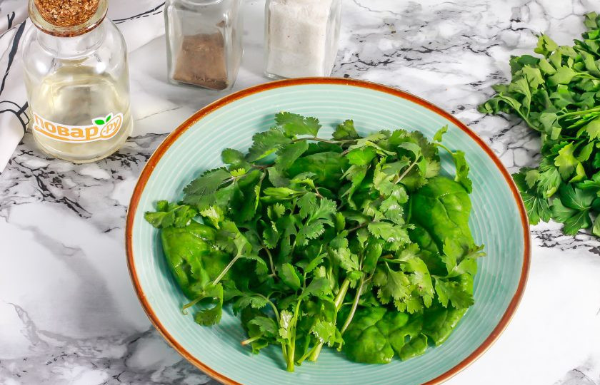 1. Этап. Салат с куриной печенью и кинзой: Промойте шпинат и кинзу в воде, стряхните лишнюю влагу. Срежьте стебли, и выложите зелень на тарелке в виде зеленой основы для салата.