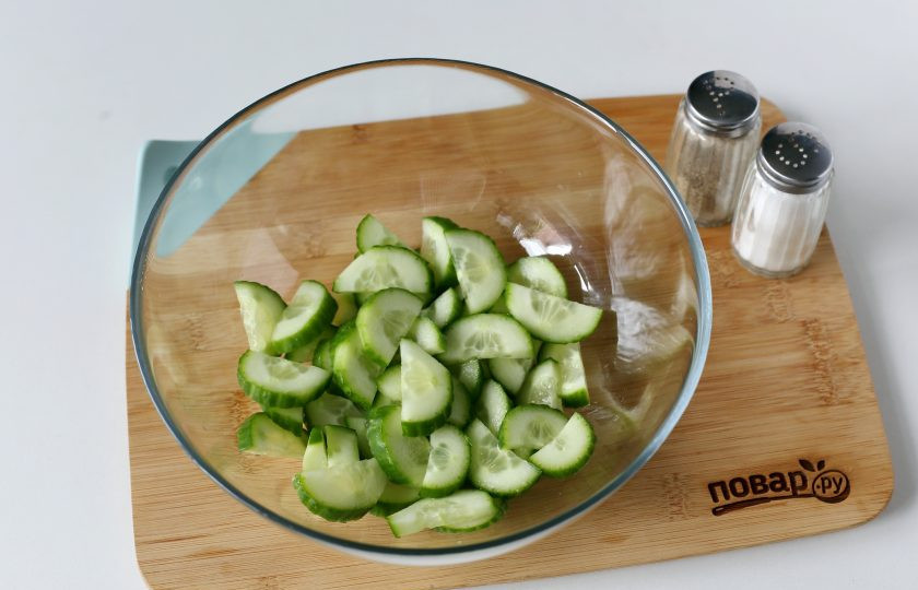 1. Этап. Салат Сырная хрустяшка: Огурец нарежьте полукружьями и переложите в салатник или в любую глубокую миску.