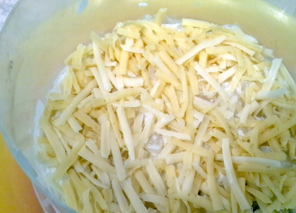 1. Этап. Салат с курицей, ананасами и грецкими орехами: Сыр трем на крупной терке. Половину сыра высыпаем на ананасы.