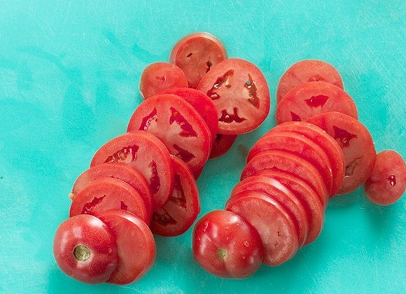 1. Этап. Куриные бедра с сыром и томатами: 5. Нарежьте сыр и томаты ломтиками.