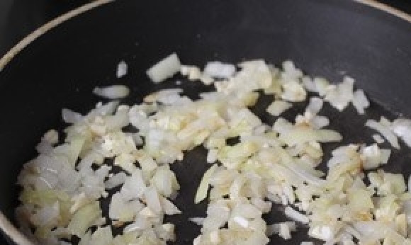 1. Этап. Рататуй в духовке: Лук и чеснок почистите, измельчите. Разогрейте масло на сковороде и сразу положите жарить в нём лук. Как он станет мягким, добавьте чеснок и бланшируйте ещё пару минут.