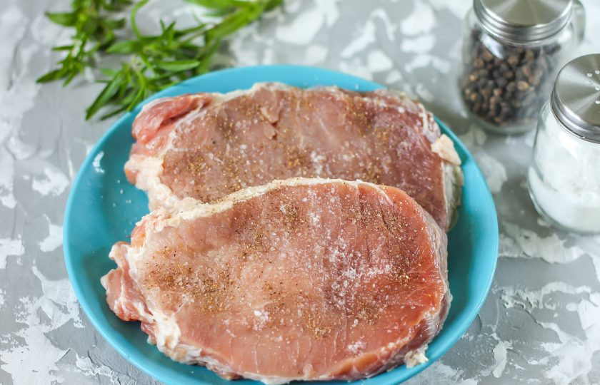 1. Этап. Стейк на электрическом гриле: Промойте свиную мякоть в воде. Пленки с боковых частей мяса не срезайте, так как благодаря им стейк будет держать форму. По желанию можете приготовить блюдо не из мякоти, а из шеи свинины, мяса на кости. Разрежьте кусок на две части. Посолите и поперчите каждый кусок со всех сторон.