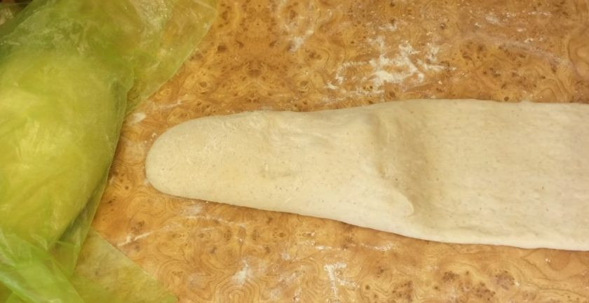 1. Этап. Белый сдобный хлеб: 1/3 часть цилиндра распластайте руками и раскатайте в тонкий пласт. Разрежьте данную часть теста на три полоски, каждую скрутите три раза и заплетите в косу. Выложите косу сверху на нераскатанную часть теста, подогните ее конец под тесто и переложите хлеб на пергамент.