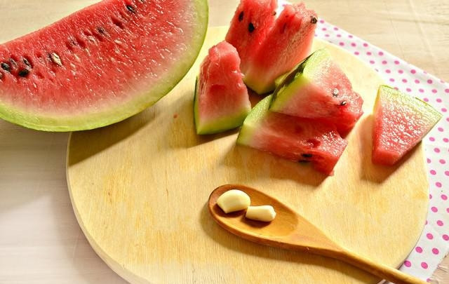 1. Этап. Консервация арбузов: 3. Срежьте чуть-чуть верхушку, чтобы их было удобно закладывать в банку. Очистите пару зубчиков чеснока.