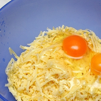 1. Этап. Пирог с сыром и мясом: Пока лук и фарш жарятся, на крупной терке натрем твердый сыр и смешаем его с двумя яйцами и двумя белками.