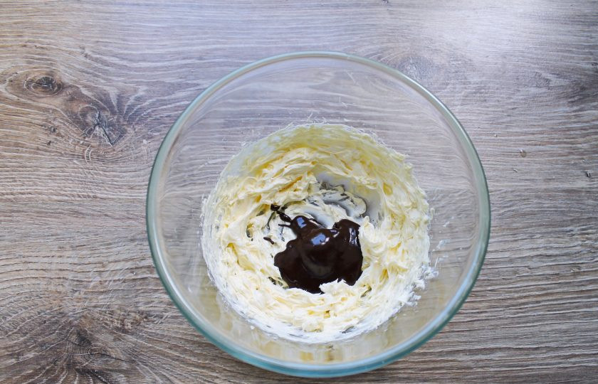 1. Этап. Капкейки Баунти: Продолжая взбивать, добавляйте шоколадную массу по одной столовой ложке, каждый раз хорошо взбивая.