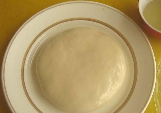 1. Этап. Дунганская лапша: 2. Примерно через полчасика выложите тесто на тарелку, смазанную растительным маслом. Обмакните его в масло со всех сторон.