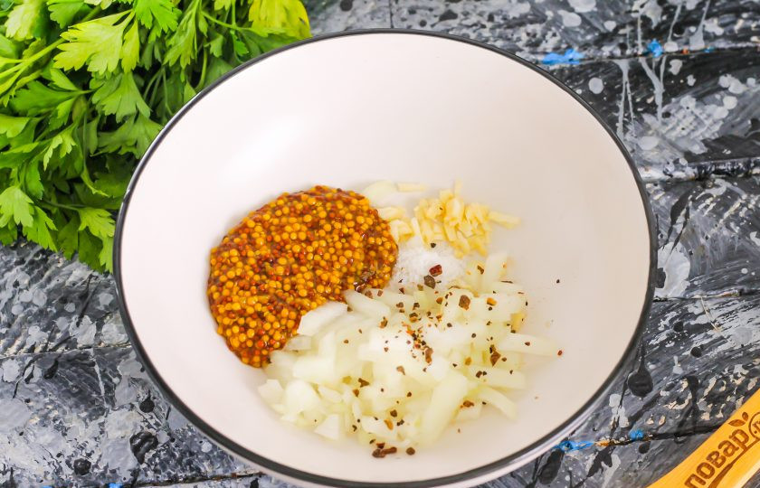 1. Этап. Маринованный язык: Очистите репчатый лук и чеснок. Мелко нарежьте и высыпьте в глубокую емкость. Добавьте щепотку соли, молотый черный перец, горчицу в зернах, масло и уксус. Перемешайте маринад.