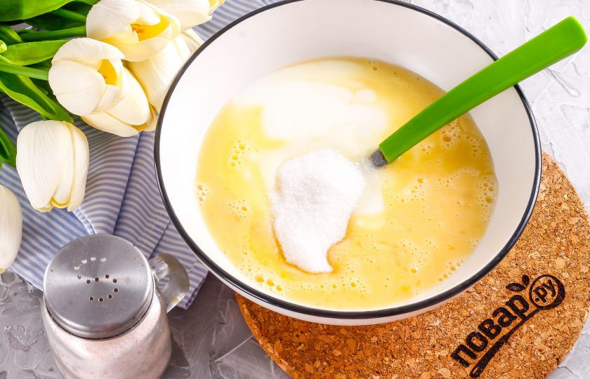 1. Этап. Оладьи с нутеллой: Куриное яйцо вбейте в глубокую емкость, туда же влейте кефир любой жирности, всыпьте сахар и соль. Взбейте все примерно 1-2 минуты.