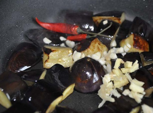 1. Этап. Баклажаны в воке: Добавляем к баклажанам подготовленные чеснок и имбирь, перец чили. Перемешиваем.