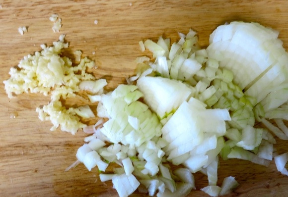 1. Этап. Котлеты из утки: 2. Первым делом налейте немного растительного масла на сковороду, разогрейте его. Очистите и измельчите лук с чесноком. Выложите их на сковороду, жарьте, периодически помешивая.