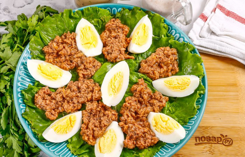 1. Этап. Салат с тунцом и вялеными помидорами: Вскройте консервы, и аккуратно выложите тунец на листья салата между яичной нарезки. Можно использовать как кусочки рыбы, так и стружку в масле. Масло не выливайте, полейте им салат в конце.