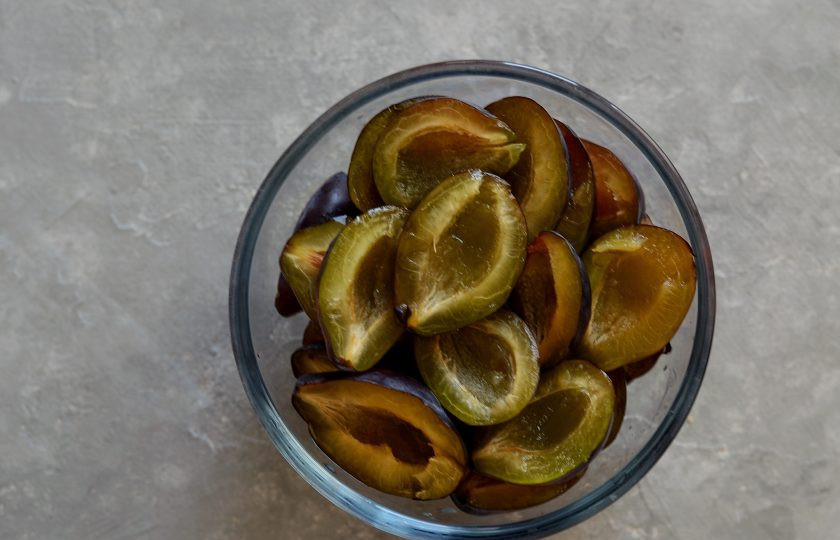 1. Этап. Варенье с орехами: Сливы помойте, разрежьте пополам и удалите косточку.