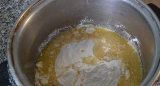 1. Этап. Соленые чесночные крендельки: Спустя 10-15 минут просейте муку к масляной массе.