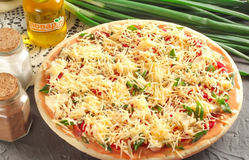 1. Этап. Болгарская пицца: Натрите на терке с мелкими ячейками твердый сыр и присыпьте им заготовку. Разогрейте духовку до 200 градусов.