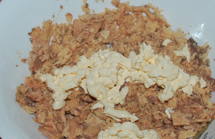 1. Этап. Cалат из рыбной консервы: Отвариваем картофель до готовности, а яйца — вкрутую. Рыбные консервы перекладываем в глубокую тарелку. Если есть кости, то удаляем. Разминаем консервы вилкой. Добавляем плавленый сырок натертый.