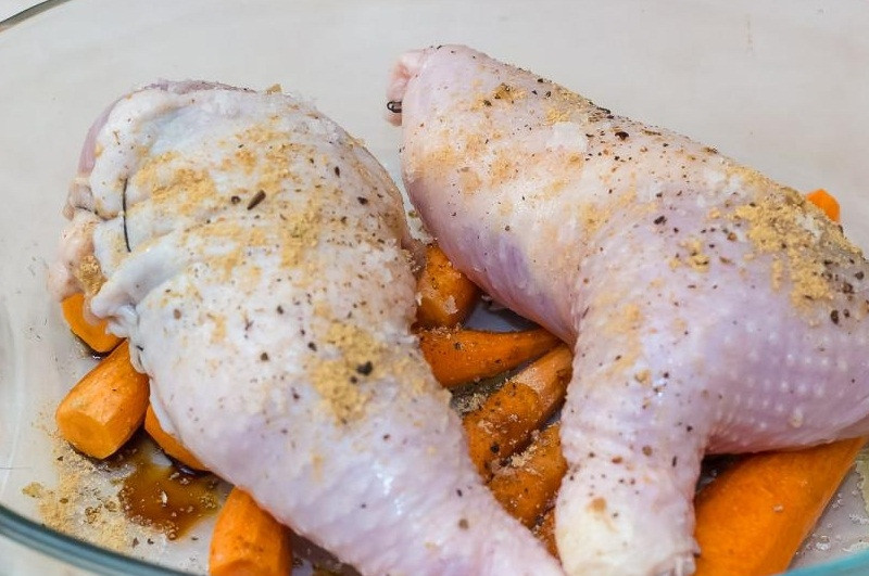 1. Этап. Фаршированные куриные окорочка в духовке: 10. Выкладываем на морковь ножки, сбрызгиваем их оливковым маслом.