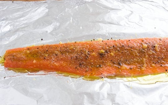 1. Этап. Лосось с зеленым соусом: 1. Вымойте филе лосося и натрите его кожуру 2 столовыми ложками оливкового масла, выложите кожей на лист фольги. Натрите на терке 3 зубчика чеснока, смешайте с цедрой одного лимона, молотым кориандром, солью и перцем, натрите полученной смесью рыбку.