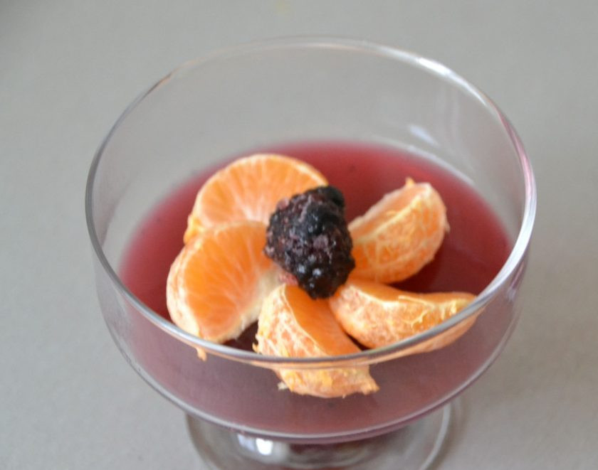 1. Этап. Прозрачное желе: Выложите дольки мандарина и ягоду ежевики на схватившуюся часть ежевичного желе.