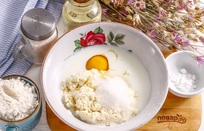 1. Этап. Панкейки из рикотты: Влейте в емкость кефир любой жирности, вбейте куриное яйцо, всыпьте сахар, соль и выложите рикотту.