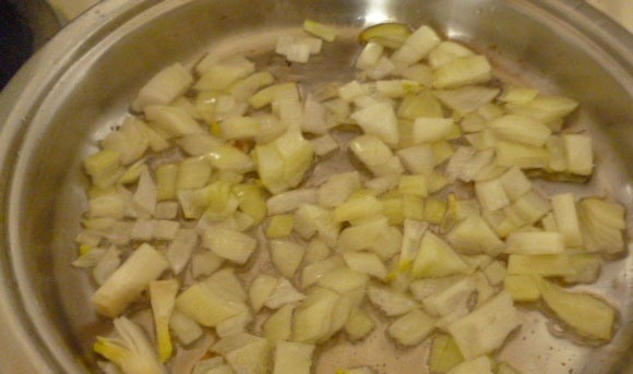 1. Этап. Салат с маринованными шампиньонами: Лук нарежьте кубиками, выложите на сковороду и обжарьте на растительном масле до золотистого цвета.