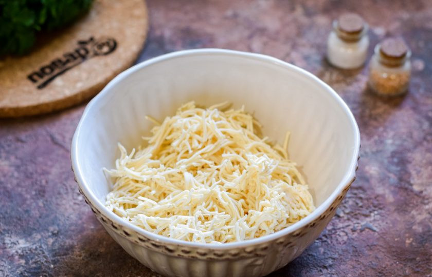 1. Этап. Крабовые палочки Очаровашки: Плавленый сыр натрите на мелкой терке, переложите в мисочку.