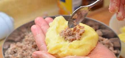 1. Этап. Картофельные котлеты с фаршем внутри: Теперь вам необходимо сформировать котлетки. Для этого выкладывайте себе на ладонь картофельное тесто, формируйте из него круглую лепешку. В центр каждой лепешки положите чайную ложку мясного фарша, сформируйте своеобразные продолговатые котлетки.