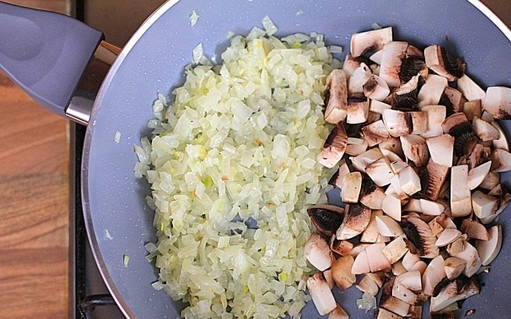 1. Этап. Картофляники с грибами: 3. На сковороде разогрейте немного растительного масла. Выложите сперва лук, обжарьте до прозрачности, а затем добавьте грибочки. Жарьте на среднем огне до готовности. В процессе посолите немного, присыпьте перцем. Также можно использовать в рецепте приготовления картофляников с грибами специи, сушеную или свежую зелень, чеснок для аромата. Готовую начинку снимите с огня и остудите.