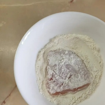 1. Этап. Куриные грудки под сырно-овощной шубкой: Обвалять филе в муке и обжарить на растительном масле в заранее разогретой сковороде до золотистой корочки.