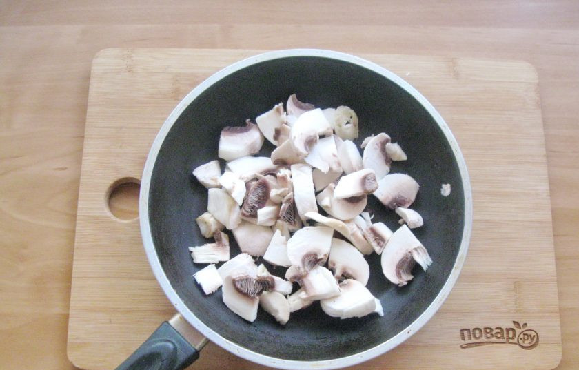 1. Этап. Ризотто по-итальянски: Шампиньоны помойте, очистите шляпки и нарежьте. Выложите в сковороду.