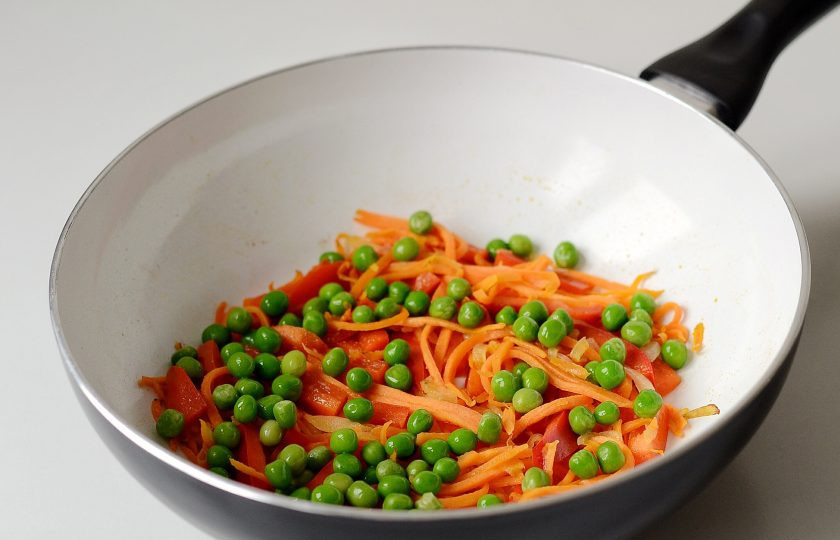 1. Этап. Вок рисом и овощами: Разогрейте вок на среднем огне. Обжарьте 1 минуту в масле репчатый лук, затем к нему добавьте морковь. Перемешайте и обжаривайте еще 2-3 минуты. В конце добавьте болгарский перец и зеленый горошек. Немного посолите овощи и поперчите.