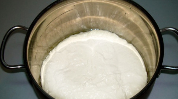 1. Этап. Осетинский пирог со свекольной ботвой: 2. Смажьте края и низ формы для выпечки растительным маслом и переложите в нее тесто. Положите сверху полотенце. Дайте возможность тесту подходить.