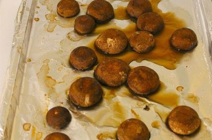 1. Этап. Фаршированные грибы с оливками и орехами: Уложите грибы на противень, посолите. Запекайте в разогретой до 180 градусов духовке 15 минут.