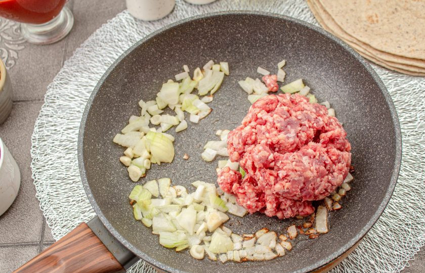 1. Этап. Буррито с фаршем и фасолью: На разогретом оливковом масле обжарьте мелко нарезанные лук и чеснок. Добавьте фарш и при помощи лопатки разбейте крупные кусочки. Жарьте фарш до румяности.