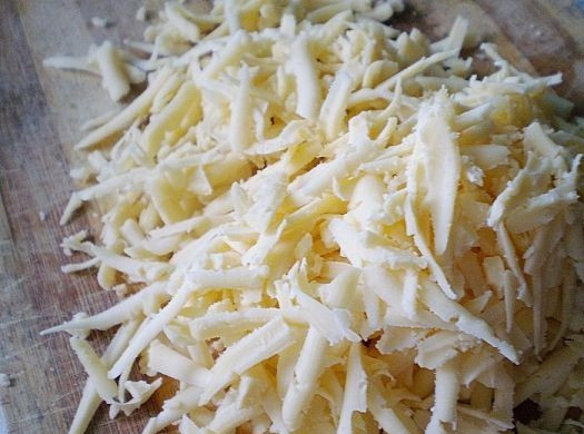 1. Этап. Слоеный салат с ветчиной: Следующий слой - сырный. Натираем сыр на терке, выкладываем на ветчину и смазываем.