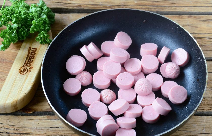 1. Этап. Хот-дог в луковых колечках: Сосиски порежьте на кусочки шириной примерно 1 см. Выложите их в сковороду с небольшим количеством растительного масла и обжарьте до легкой золотистой корочки.