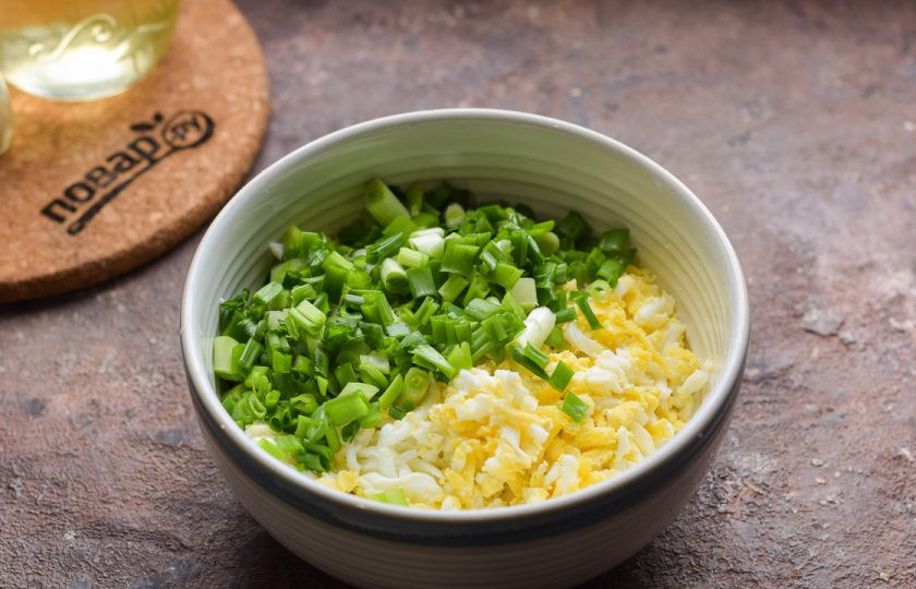 1. Этап. Блинчики с яйцом и луком: Куриные яйца предварительно отварите вкрутую 10 минут в подсоленной воде. После яйца почистите и нарежьте кубиками, переложите в миску. Зеленый лук ополосните и просушите, нарежьте мелко. Добавьте лук к яйцам, всыпьте соль и перец по вкусу, перемешайте.