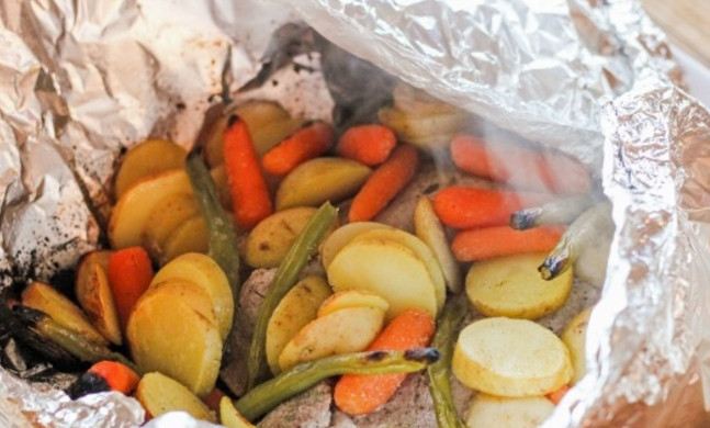 1. Этап. Свинина в фольге: Картофель промойте хорошенько и нарежьте кружочками или тонкими дольками, смешайте все овощи с маслом, тмином и чесночной солью, выложите к мясу.